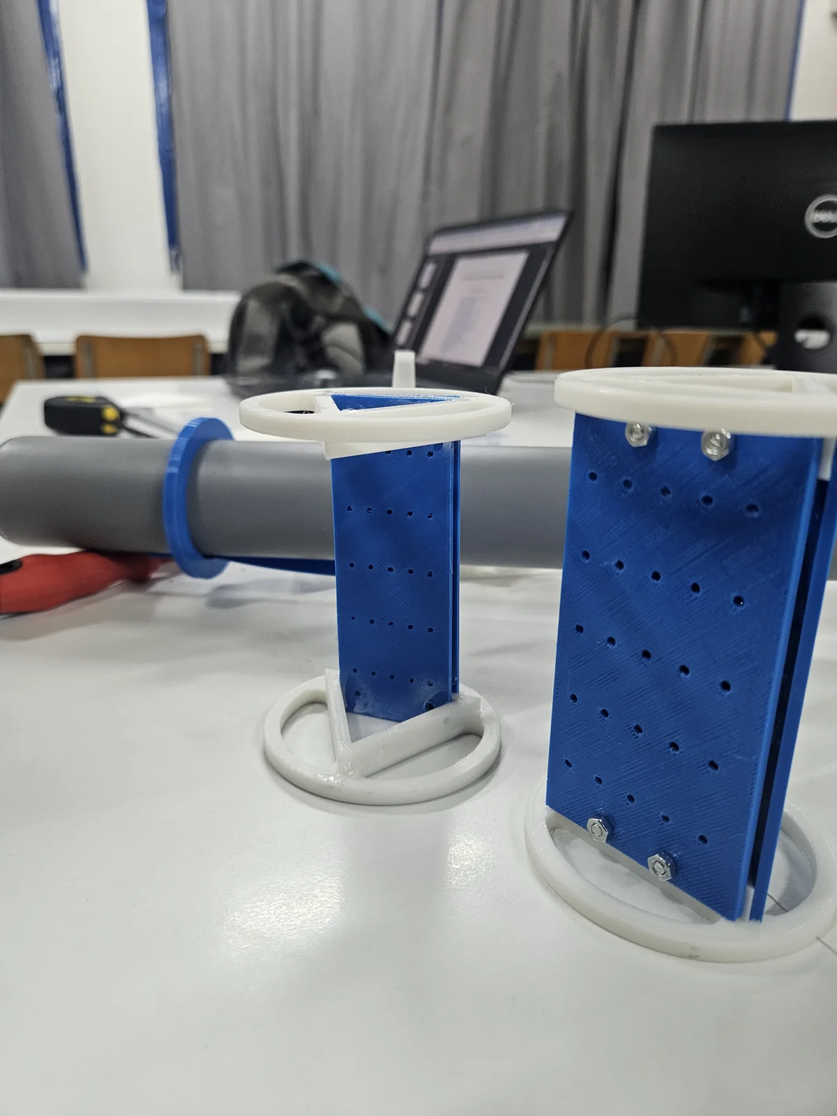 Blue electronics mounts with white rings on the workshop bench